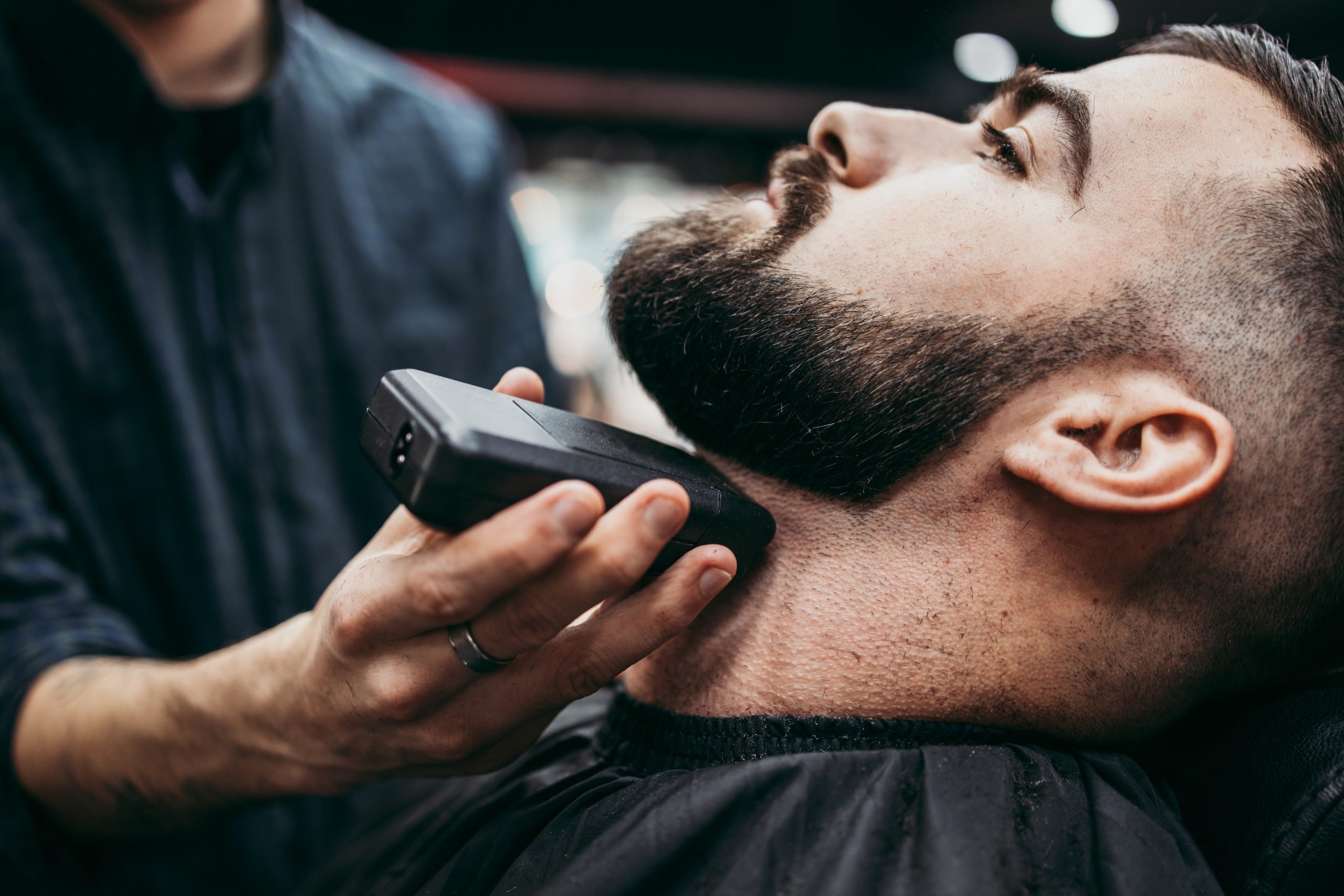 Friseur Augustin in Gelsenkirchen-Mann wird der Bart mit einem Rasierer gestuzt
