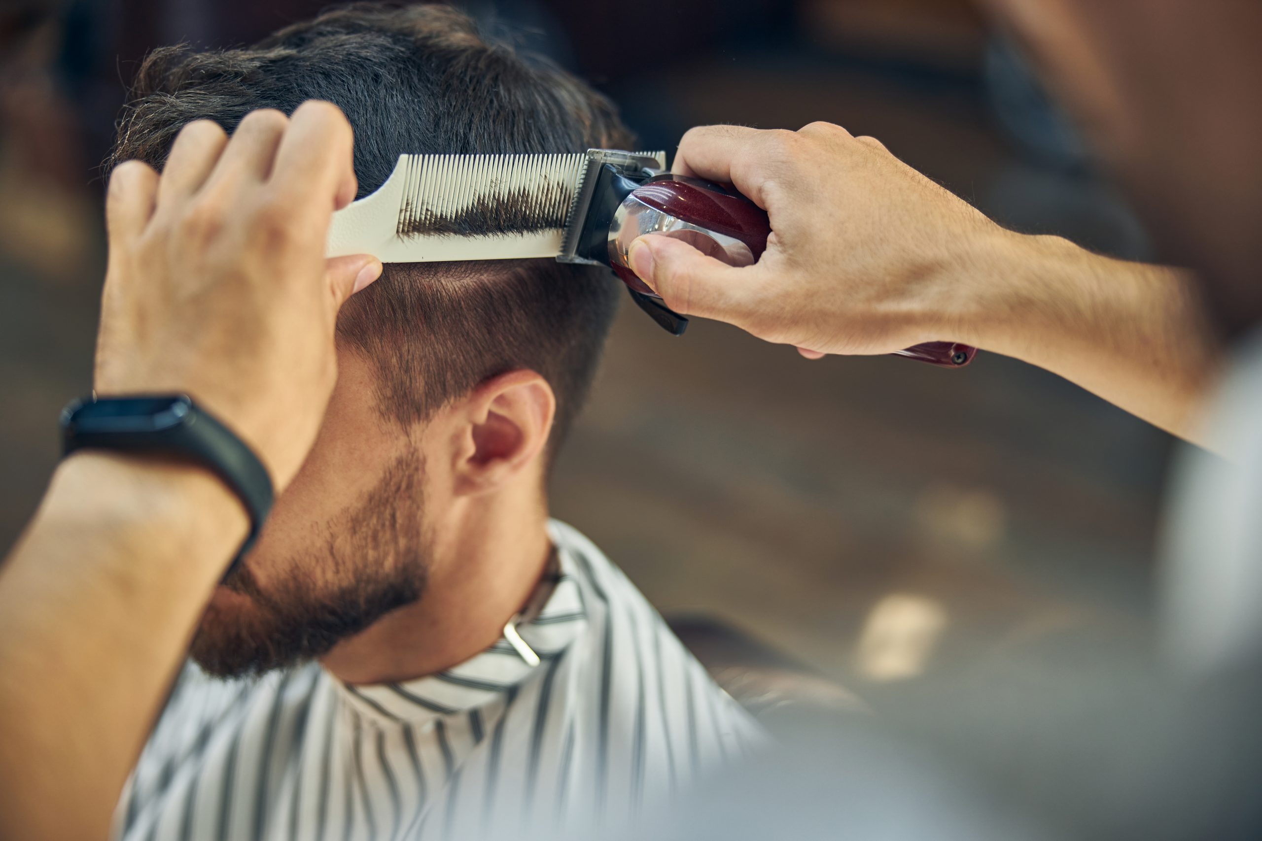 Friseur Augustin in Gelsenkirchen-Schneiden einer Kurzhaarfrisur mit einem Rasierer an einem Mann