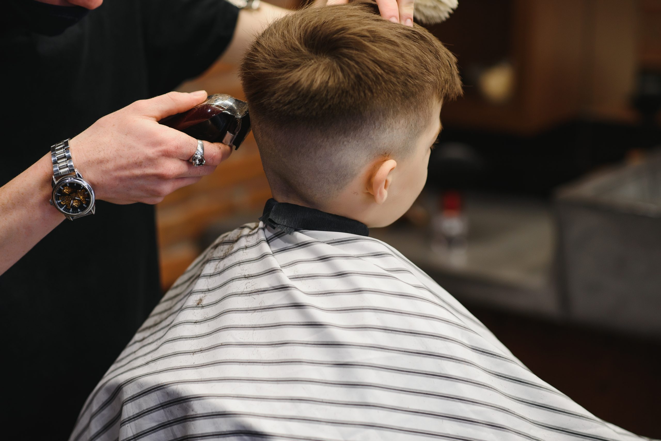 Friseur Augustin in Gelsenkirchen-Schneiden einer Kinderfrisur mit Rasierer an einem Jungen